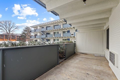 a balcony with a fence and a building in the background